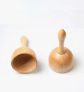 Two small natural wooden massage hand bells for body sculpting and cellulite massage, displayed on a white background.